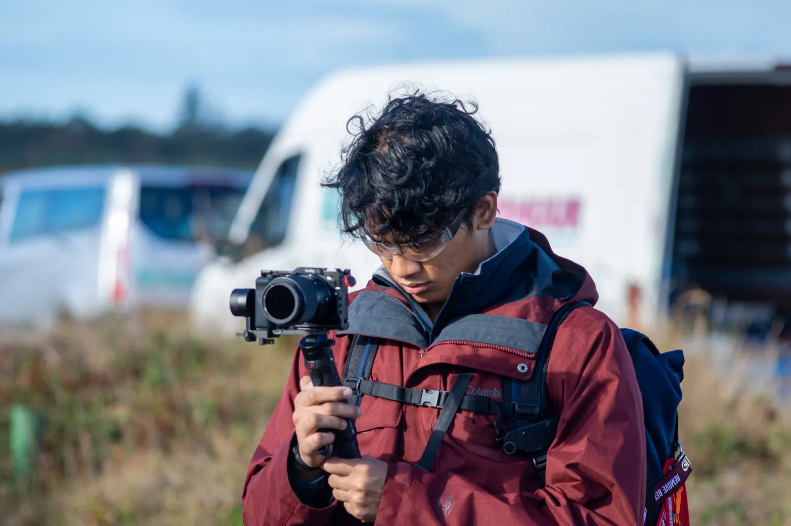 Diovandi filming with a camera on a handheld gimbal at the launch site, a van in the background.